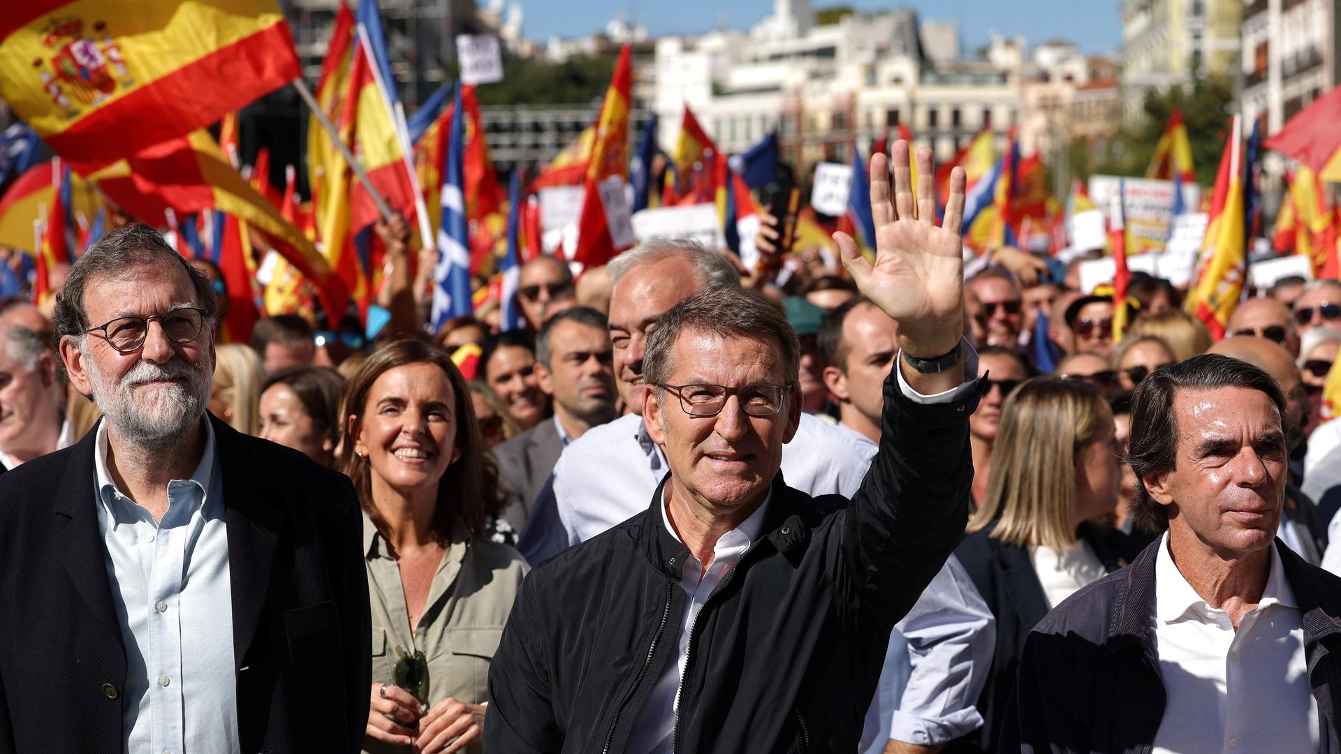 Alberto Nunez Feijóo geht an der Spitze von tausenden Menschen und winkt in die Kamera. Neben ihm die früheren spanischen Ministerpräsidenten Mariano Rajoy (l.) und José Maria Aznar (r.).