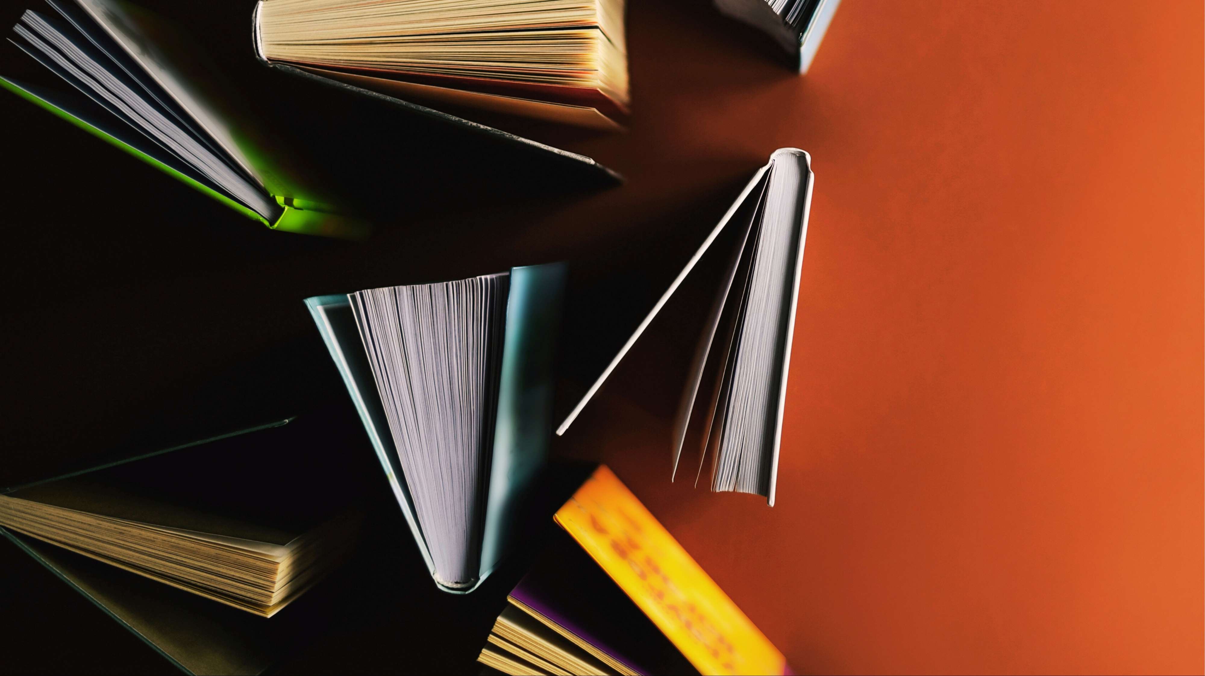 Durcheinander aufgestellte Bücher auf einem roten Tisch