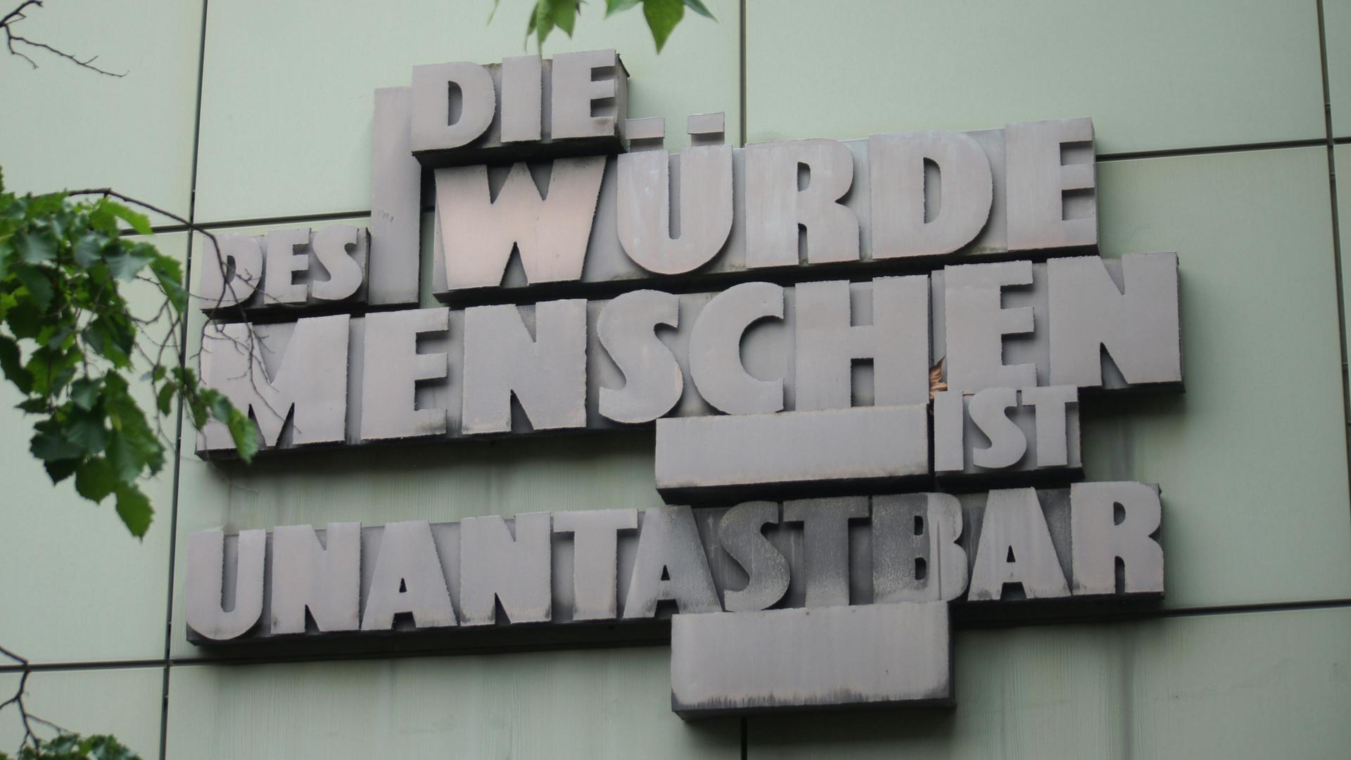 Artikel 1 des Grundgesetzes der Bundesrepublik Deutschland, an einer Wand eines Justizgebäudes in Frankfurt.