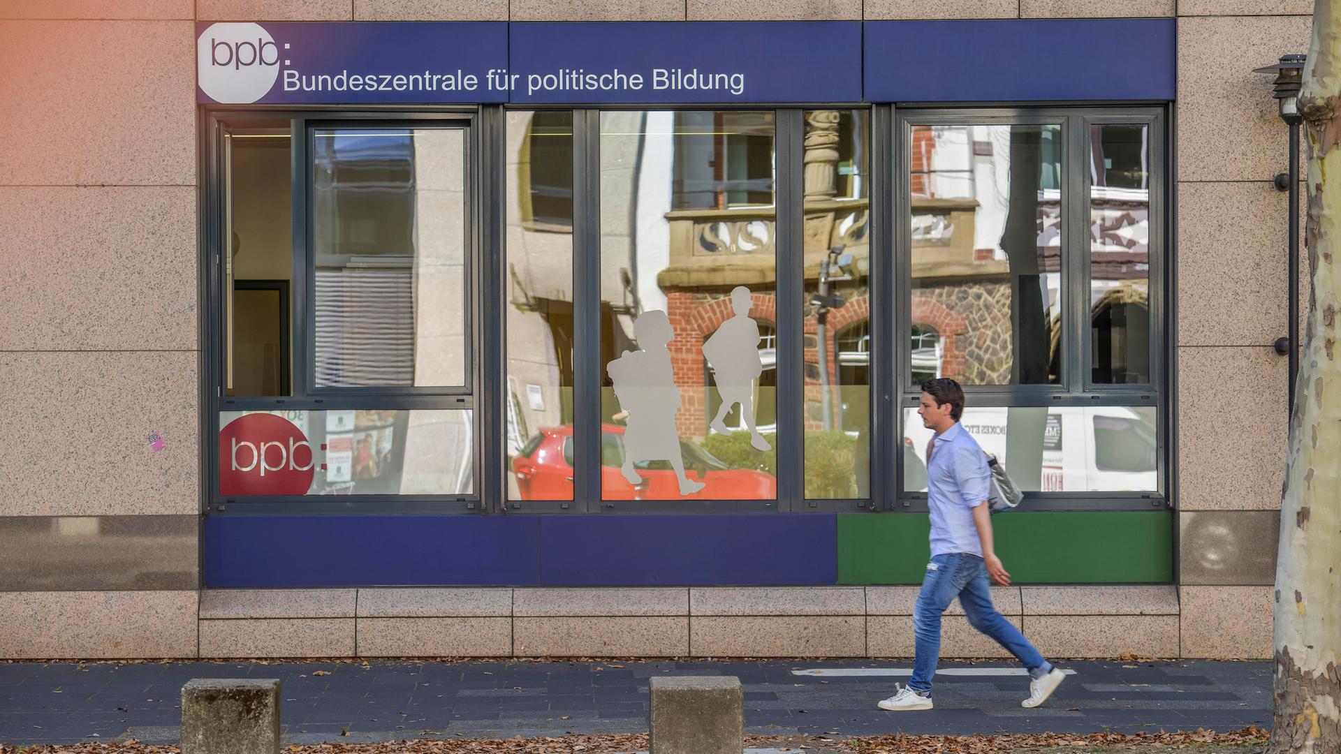 Schaufenster der Bundeszentrale für politische Bildung in Bonn, an dem ein Junge vorbeigeht.