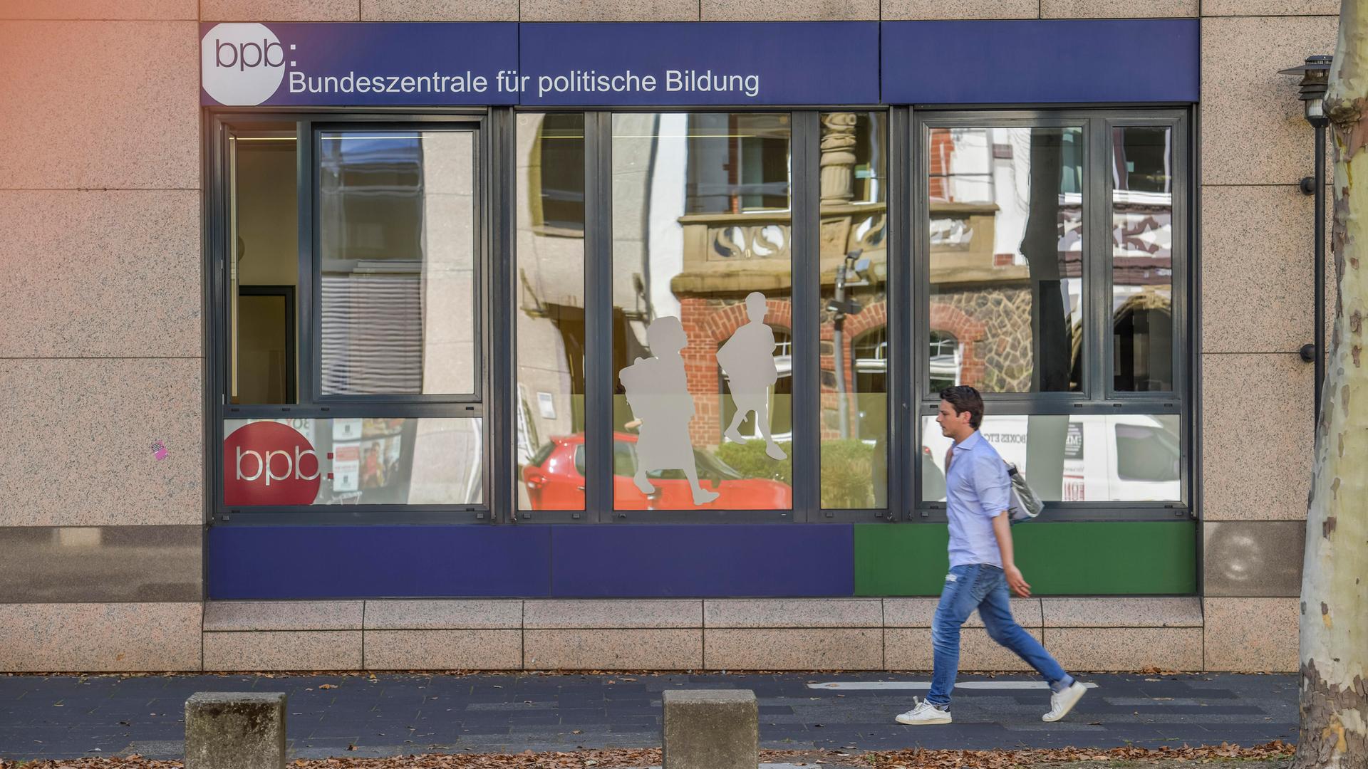 Schaufenster der Bundeszentrale für politische Bildung in Bonn, an dem ein Junge vorbeigeht. 
