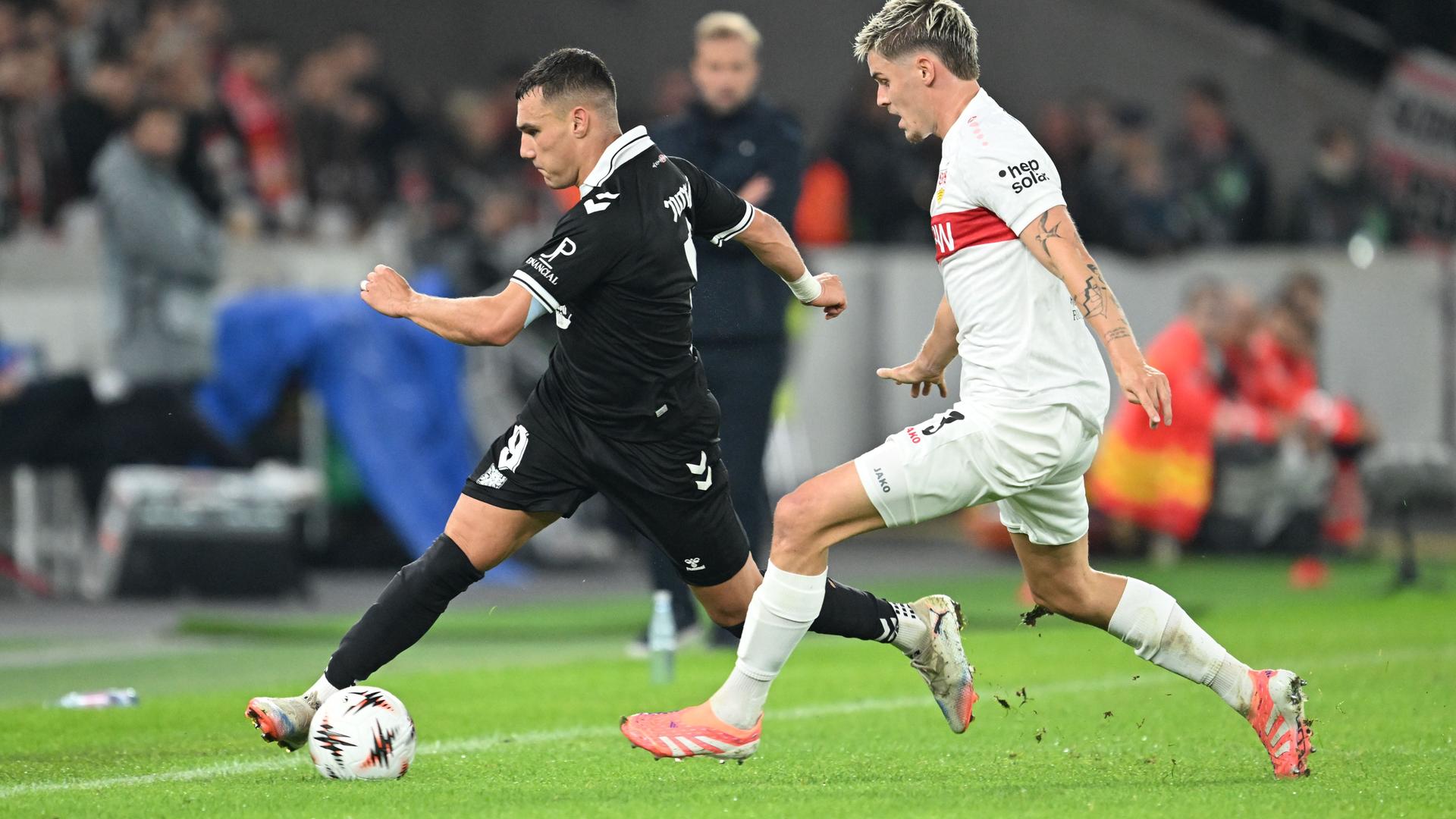 Zwei Fußballspieler kämpfen um den Ball.