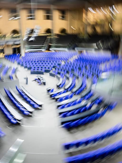 Der leere Plenarsaal des Deutschen Bundestages wirkt durch eine Kamerabewegung verwackelt und in Bewegung.