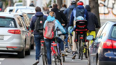 Zahlreiche Radfahrer und Radfahrerinnen stauen sich in der Leipziger Innenstadt an einer Ampel.