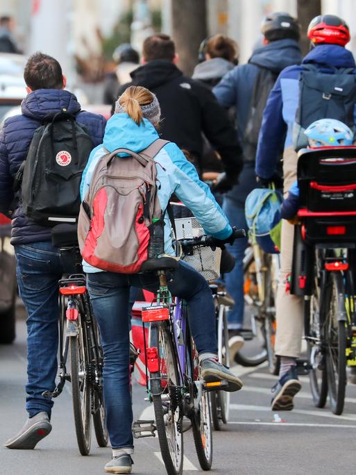 Zahlreiche Radfahrer und Radfahrerinnen stauen sich in der Leipziger Innenstadt an einer Ampel.
