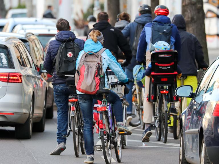 Zahlreiche Radfahrer und Radfahrerinnen stauen sich in der Leipziger Innenstadt an einer Ampel.