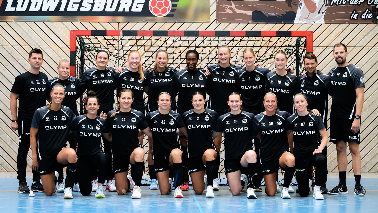 Trainer und Spielerinnen des Handballvereins HB Lugwigsburg posieren für ein Mannschaftsbild.