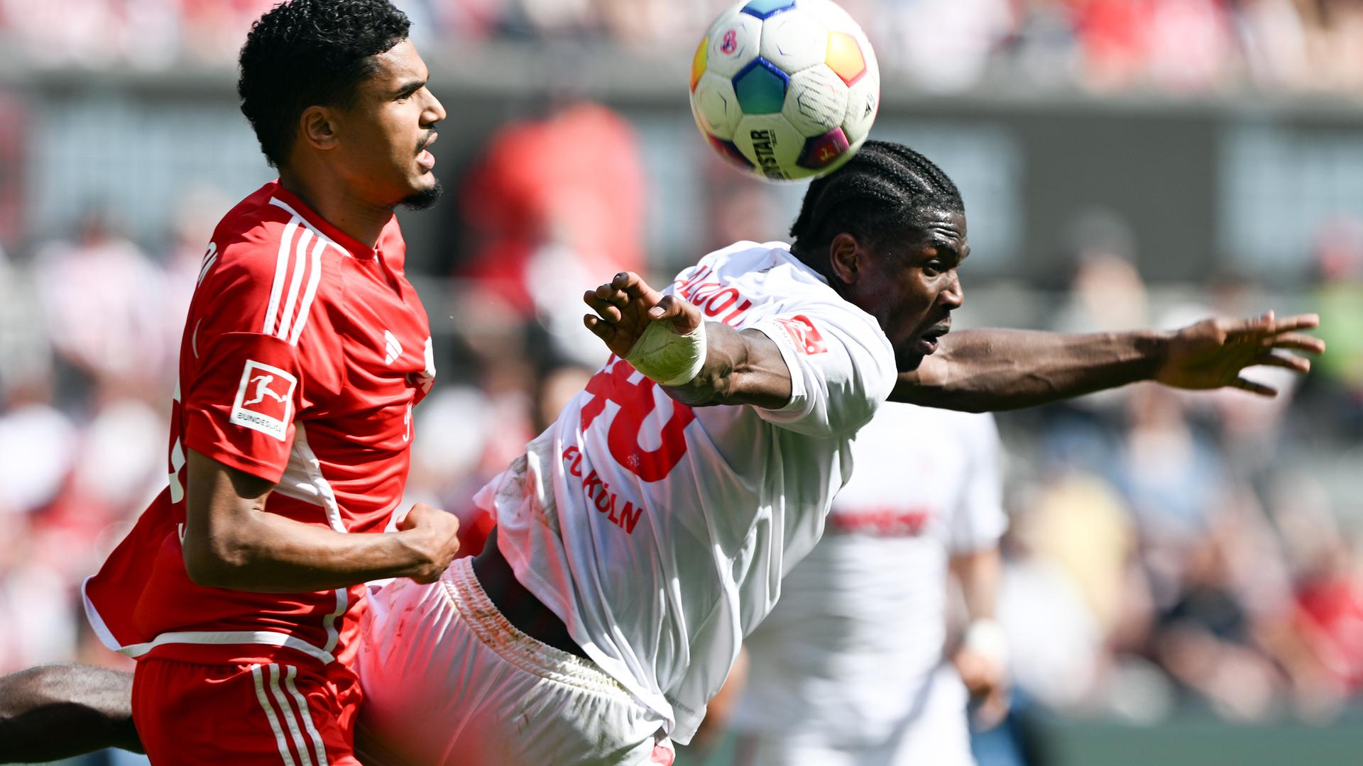 Kölns Faride Alidou und Berlins Danilho Doekhi kämpfen um den Ball. Kölns Faride Alidou und Berlins Danilho Doekhi kämpfen um den Ball.