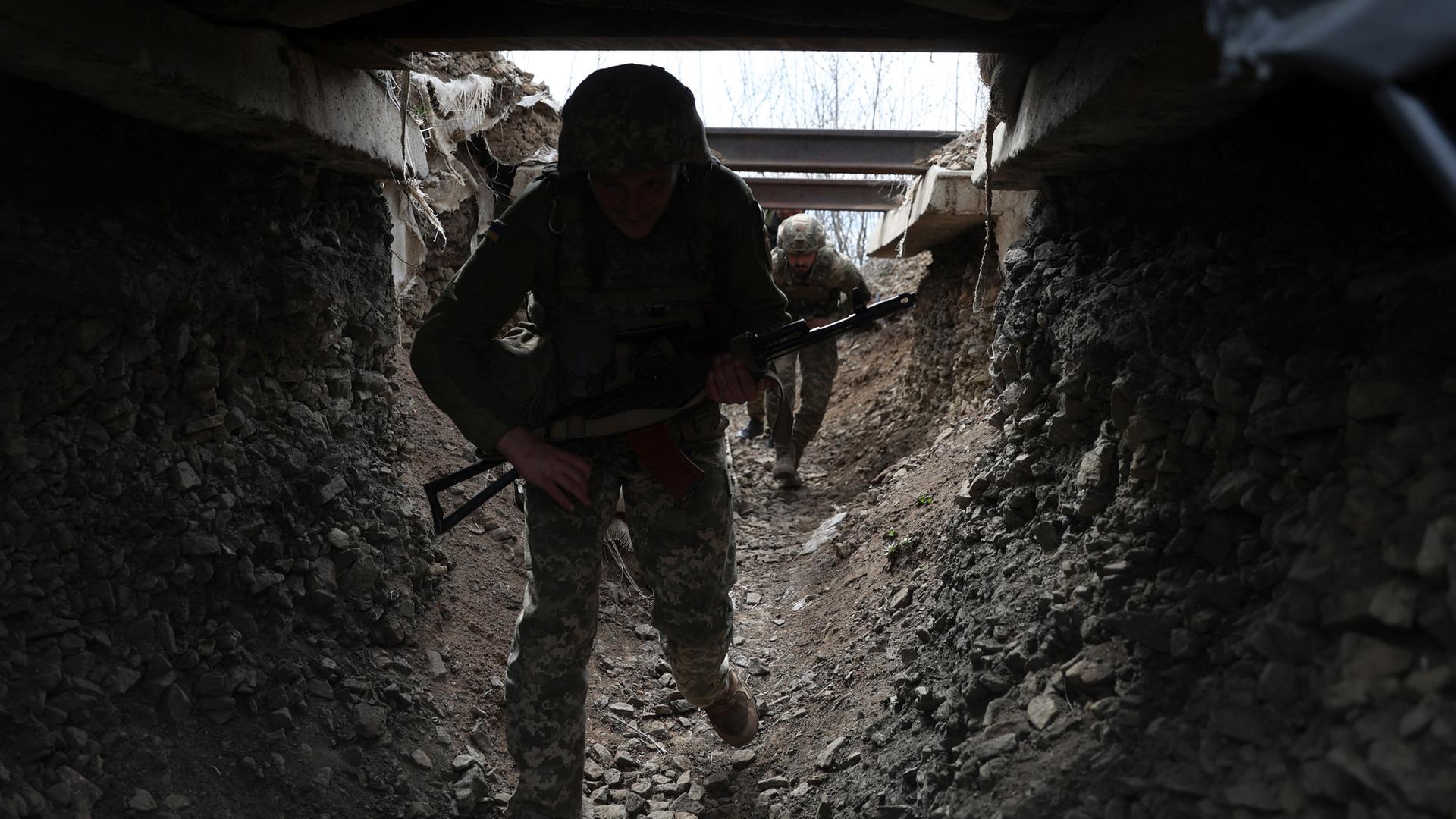 Ukrainische Soldaten gehen durch einen Tunnel an der Frontlinie in Luhansk.
