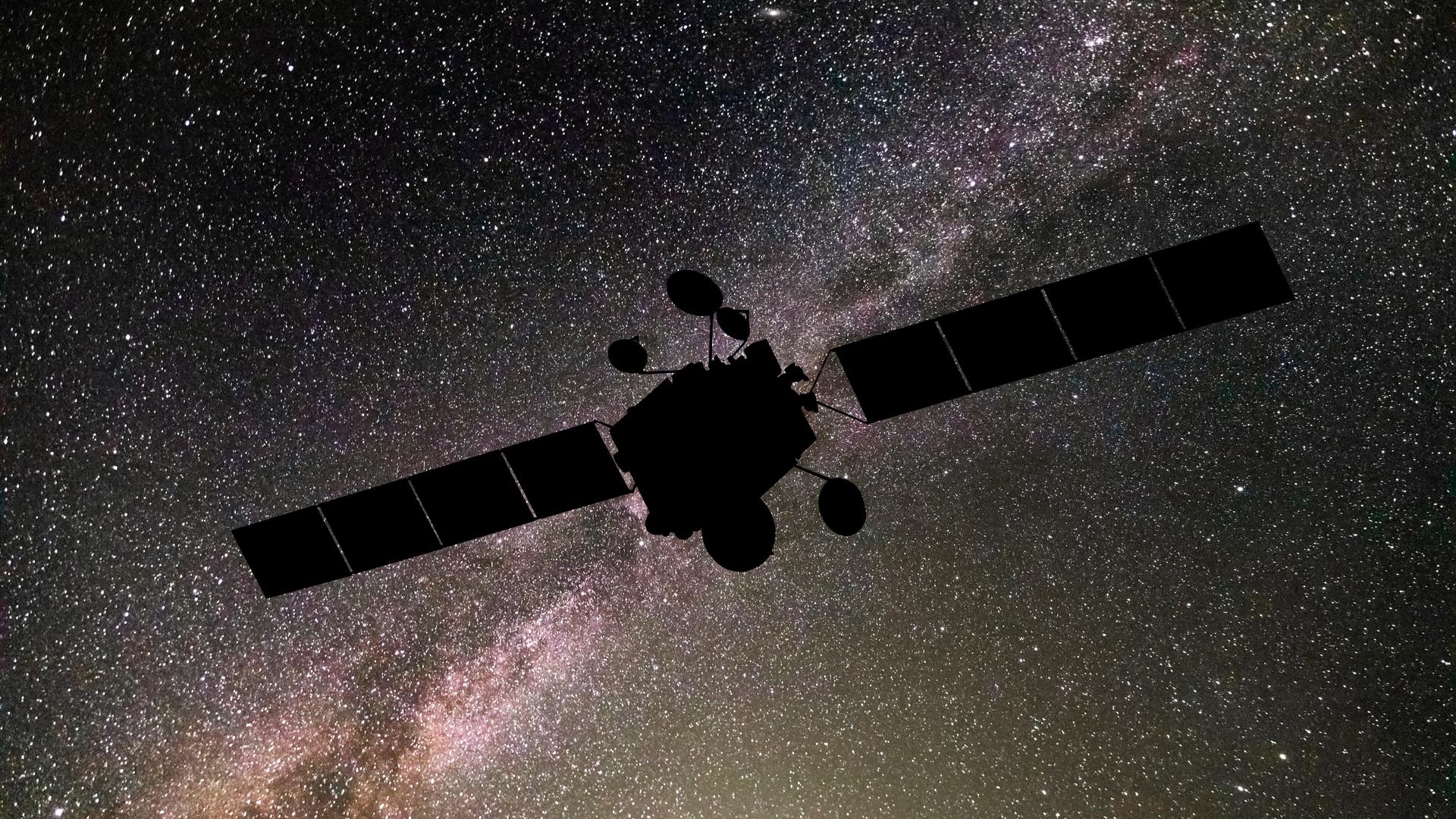 Die Silhouette eines Satelliten vorm Himmel im Weltall. Die Silhouette eines Satelliten vorm Himmel im Weltall.