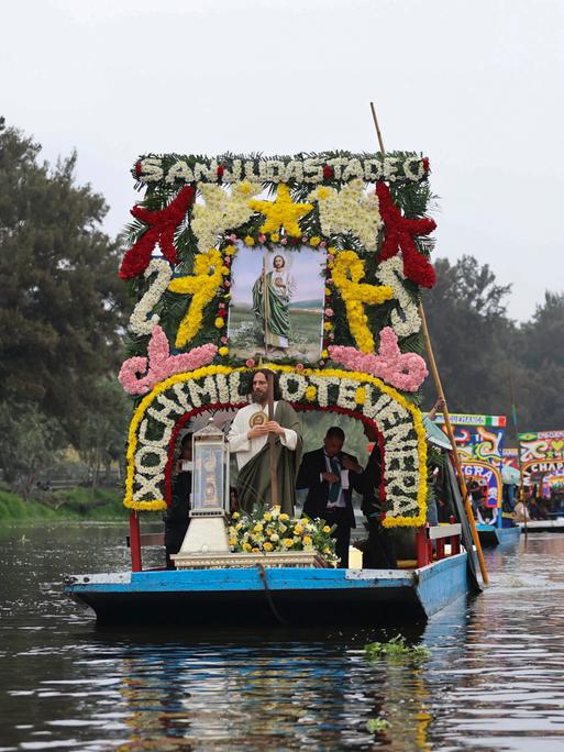 Eine Reliquie des Heiligen Thaddäus wird in einer Glasurne auf einer geschmücktenTrajinera, einem Boot, durch die Kanäle von Xochimilco transportiert.