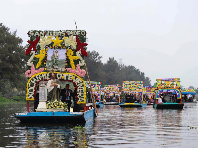Eine Reliquie des Heiligen Thaddäus wird in einer Glasurne auf einer geschmücktenTrajinera, einem Boot, durch die Kanäle von Xochimilco transportiert.