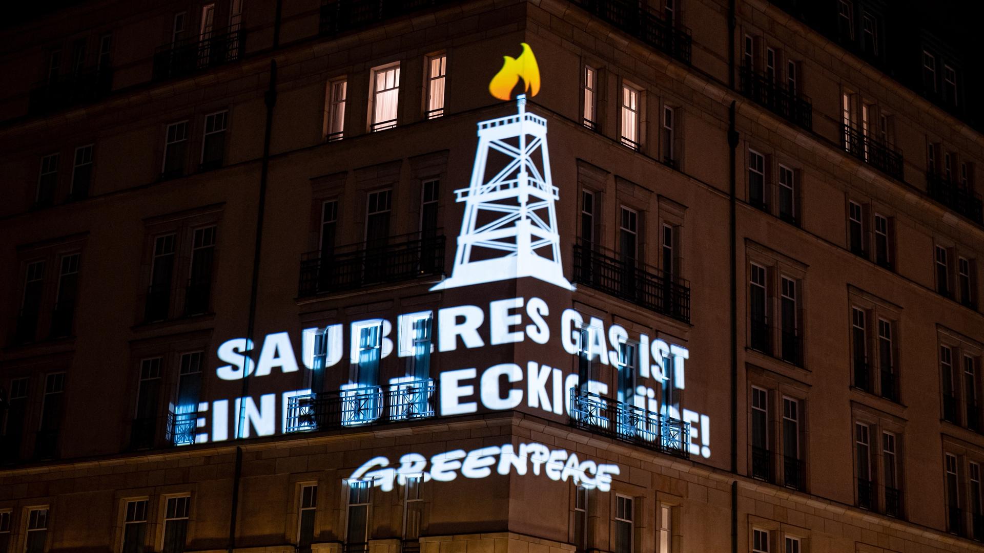 Greenpeace-Aktivisten projizieren am 9. Dezember 2024 den Schriftzug "Sauberes Gas ist eine dreckige Lüge" auf das Hotel Adlon in Berlin-Mitte. Anlass ist der der "World LNG Summit" dort.