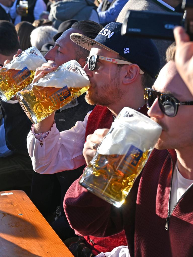 Mehrere Männer trinken Bier aus großen Gläsern in der Augustiner Festhalle auf dem 190. Oktoberfest 2025 auf der Theresienwiese.
