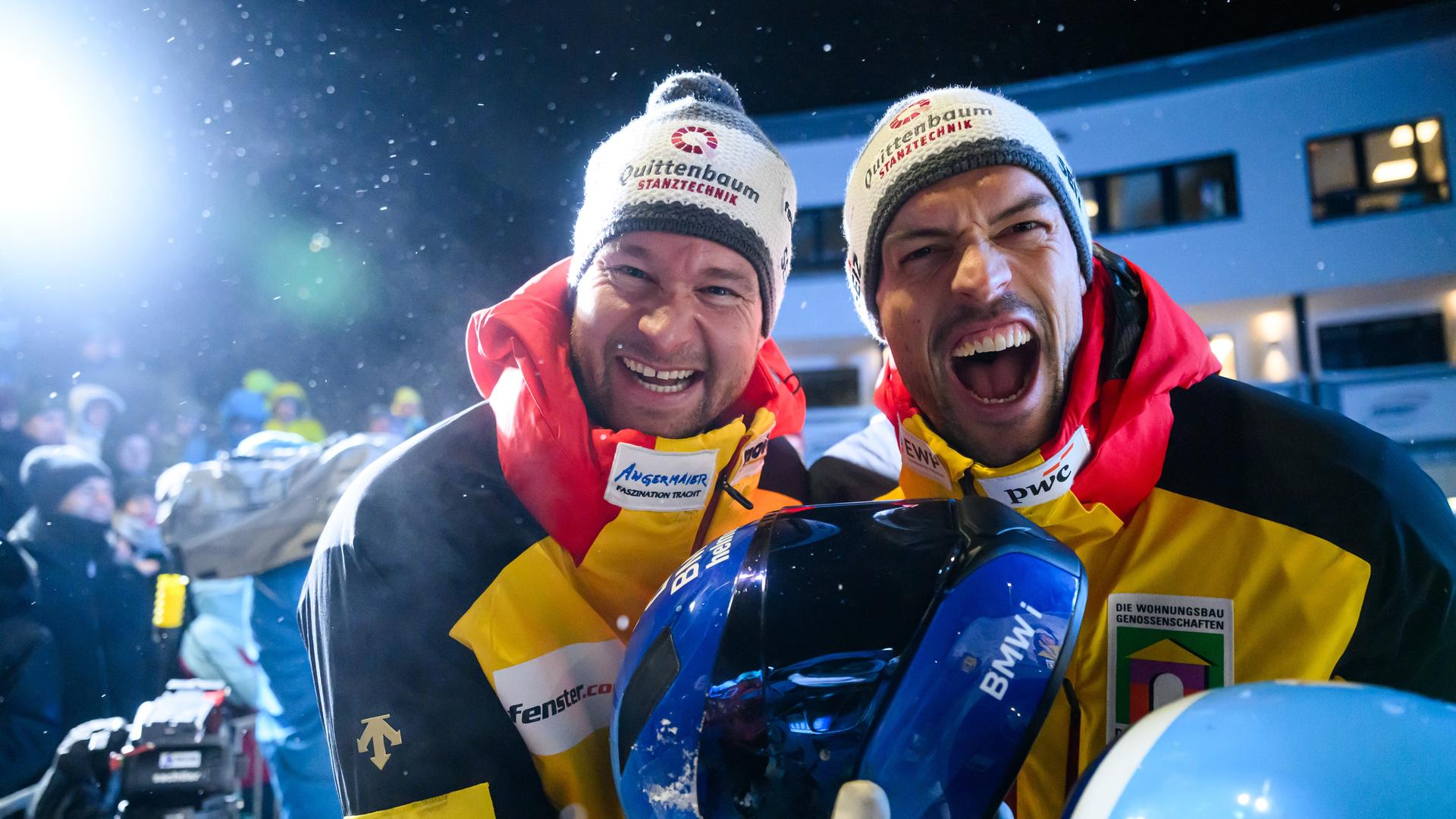 Zwei Männer mit Pudelmützen jubeln in die Kamera.