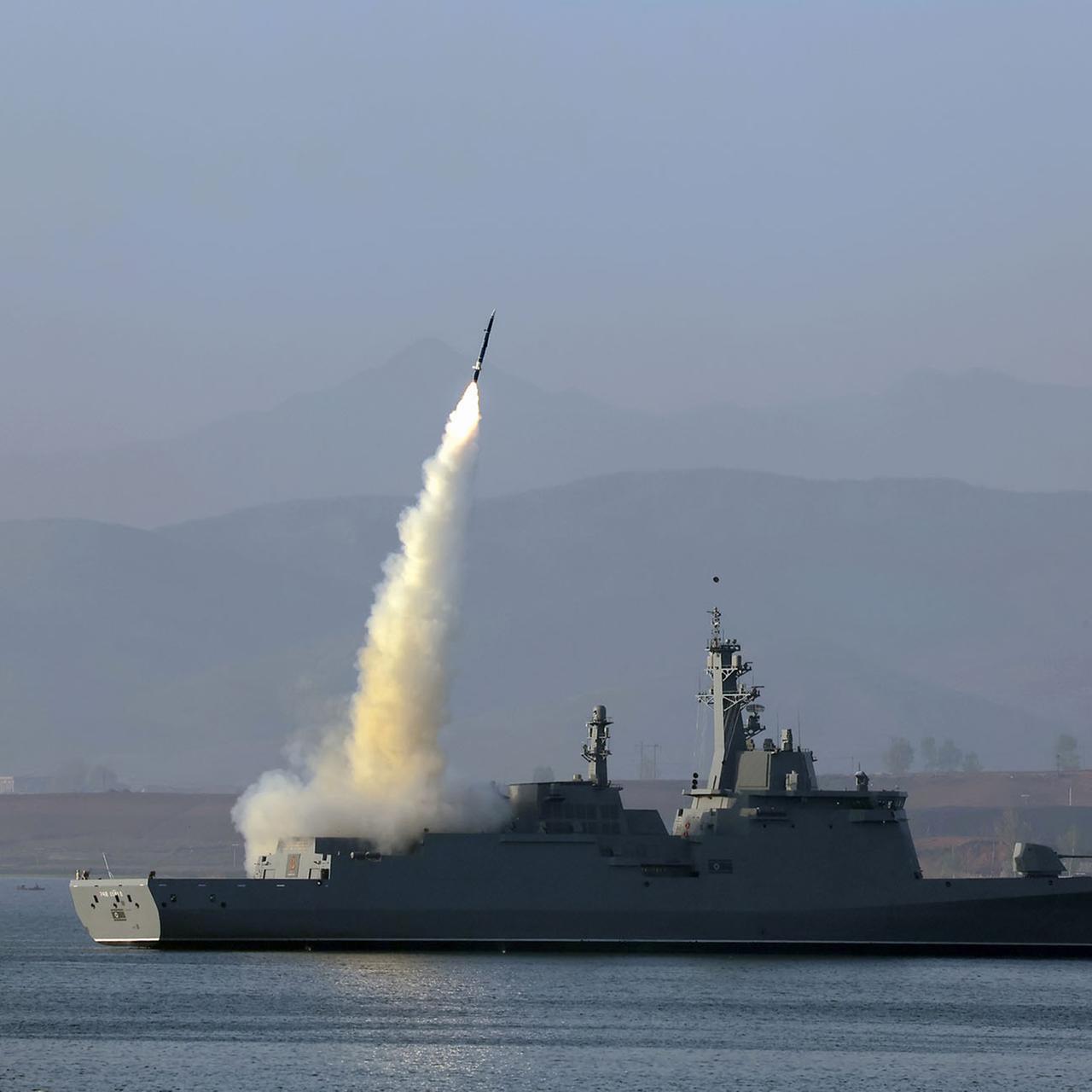 Zu sehen ist ein Kriegsschiff, von dem aus eine Rakete startet und mit einem Feuerschweif nach oeben schnellt.