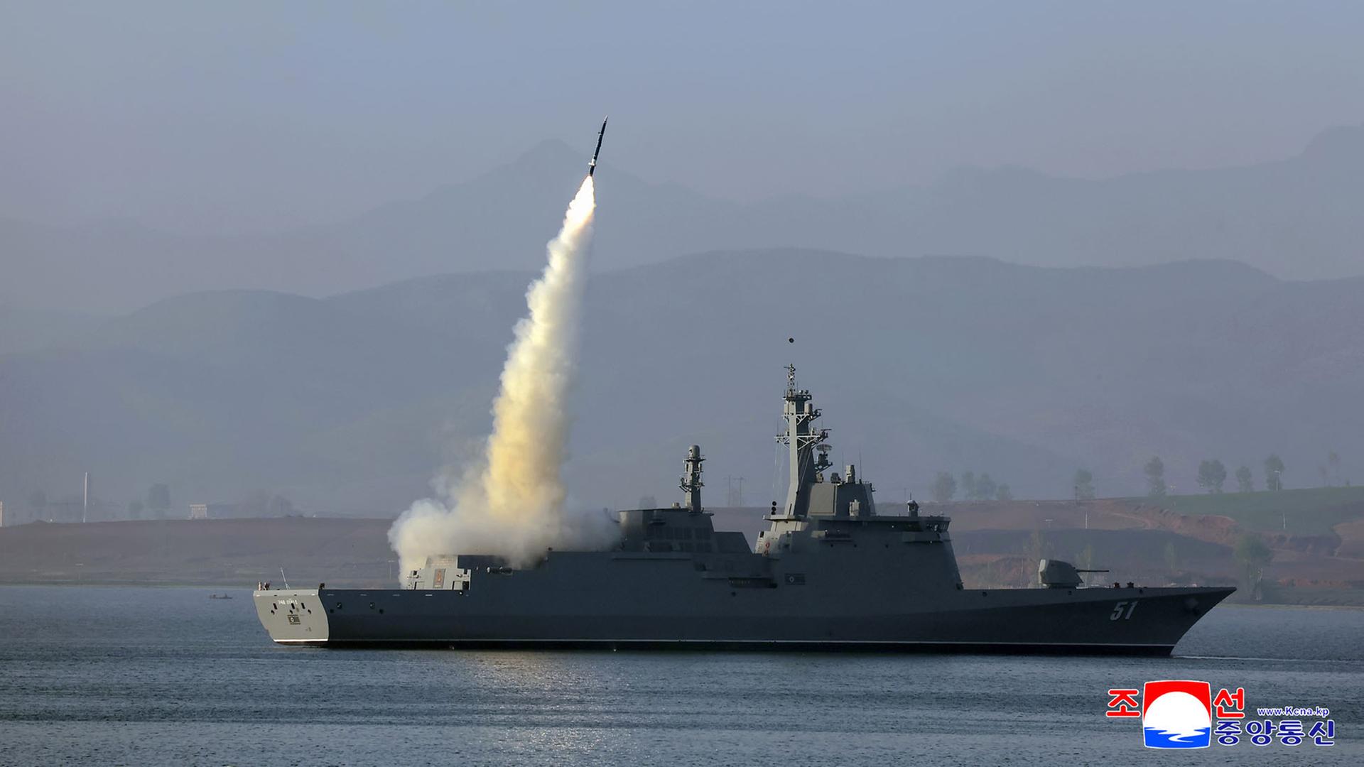 Zu sehen ist ein Kriegsschiff, von dem aus eine Rakete startet und mit einem Feuerschweif nach oeben schnellt.