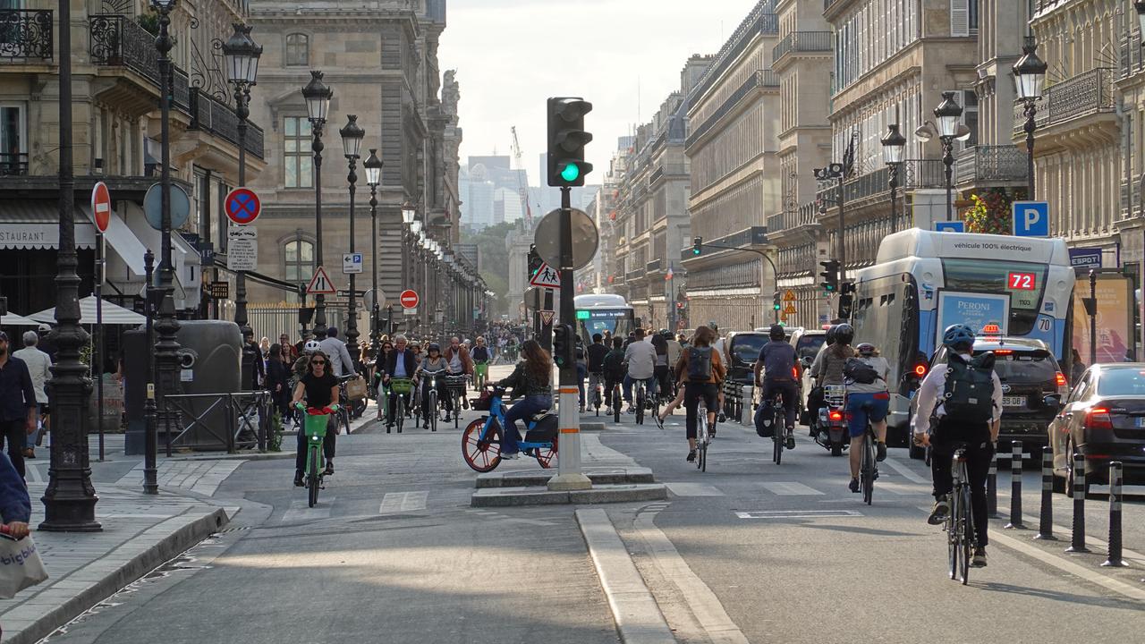 Zahlreiche Fahrradfahrende bewegen sich durch die Rue de Rivoli in Paris.
