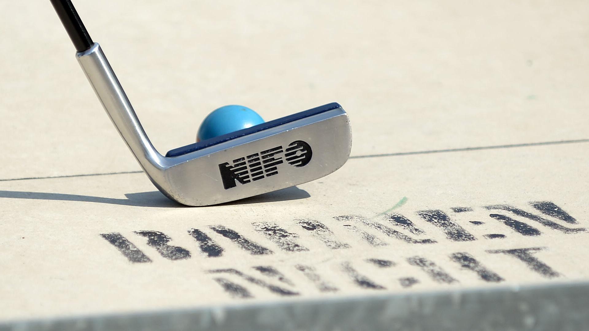 Ein Minigolfschläger und ein Ball sind zu sehen.