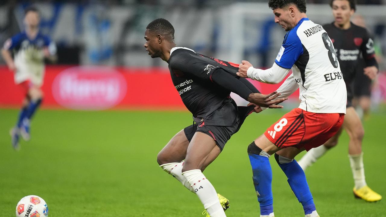 Christian Kofane (Bayer Leverkusen) und Daniel Elfadli (r, Hamburger SV) kämpfen um den Ball. 