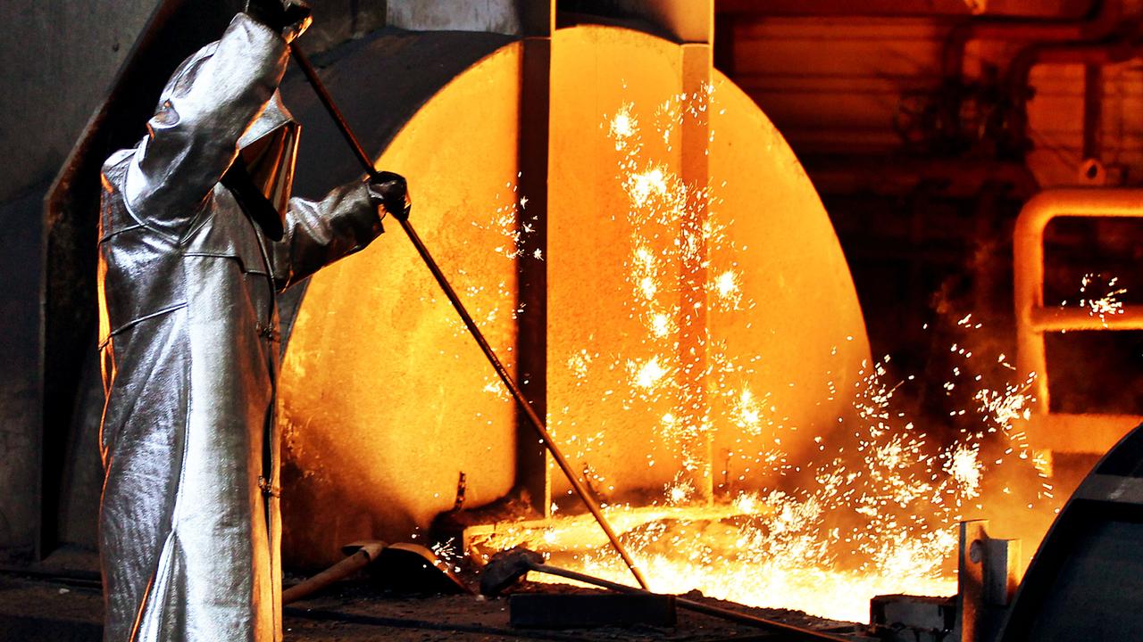 Ein Mitarbeiter von Thyssenkrupp zieht in silberner Schutzkleidung in Duisburg am Hochofen im Stahlwerk eine Probe Ein Mitarbeiter von Thyssenkrupp zieht in silberner Schutzkleidung in Duisburg am Hochofen im Stahlwerk eine Probe