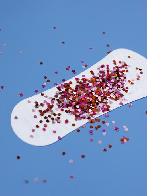 Auf einer Slipeinlage liegt ein Häufchen roter Glitzerpartikel.