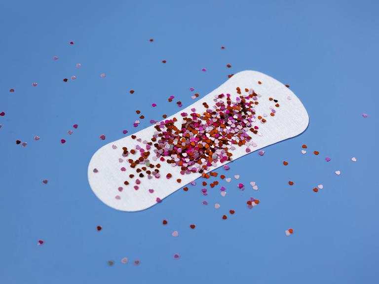 Auf einer Slipeinlage liegt ein Häufchen roter Glitzerpartikel.