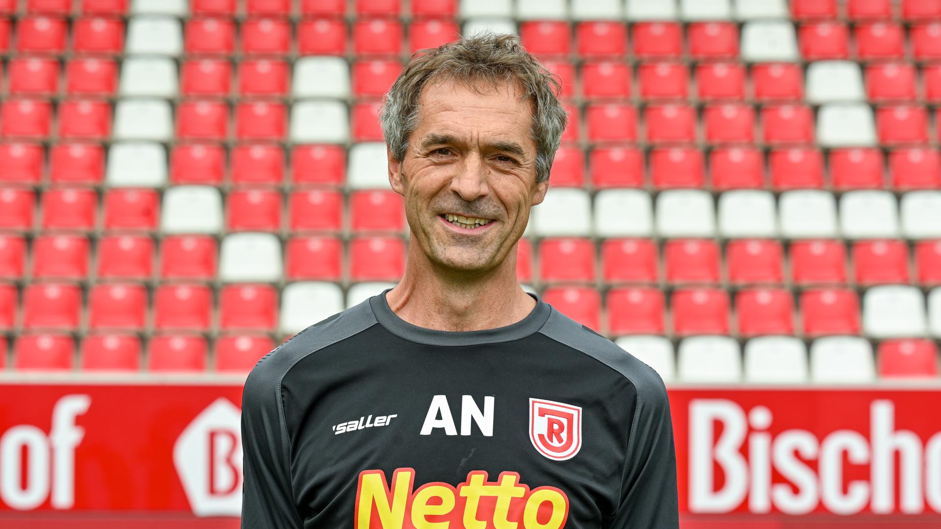 Andreas Harlass-Neuking, Teamarzt vom SSV Jahn Regensburg steht im Trikot und lächelt in die Kamera.