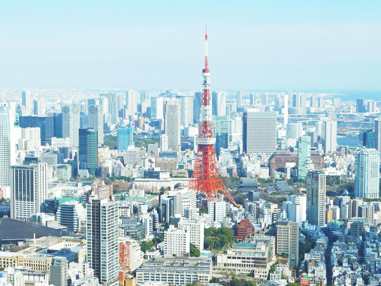 Ein Blick auf den rot-weißen Tokyo Tower inmitten eines Häusermeeres in Tokyo