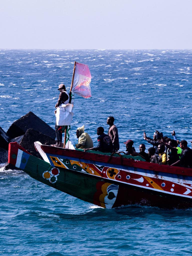 Eine Gruppe von Migranten feiert, dass sie die Überfahrt von Afrika nach Europa überlebt haben. Sie winken vom übervollen Boot. 358 Menschen erreichten im Laufe von drei Stunden die Kanareninsel El Hierro am 22. August 2024.