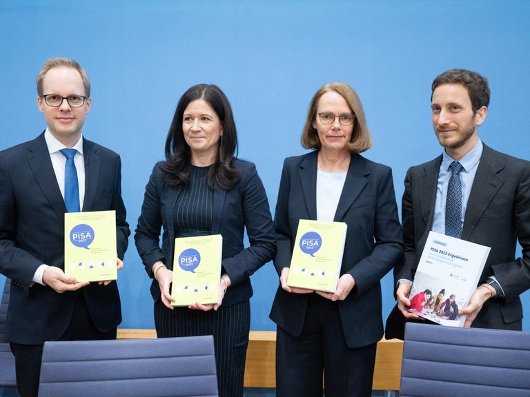 Berlin: Jens Brandenburg (FDP, l-r), Parlamentarischer Staatssekretär im Bundesministerium für Bildung und Forschung, Katharina Günther-Wünsch (CDU), Senatorin für Bildung, Jugend und Familie in Berlin und Präsidentin der Kultusministerkonferenz, Doris Lewalter, Nationale PISA-Projektleiterin, und Francesco Avvisati, Ko-Autor der PISA-Studie, halten bei der Vorstellung der Pisa-Studie 2022 in der Bundespressekonferenz Exemplare der Studie. 