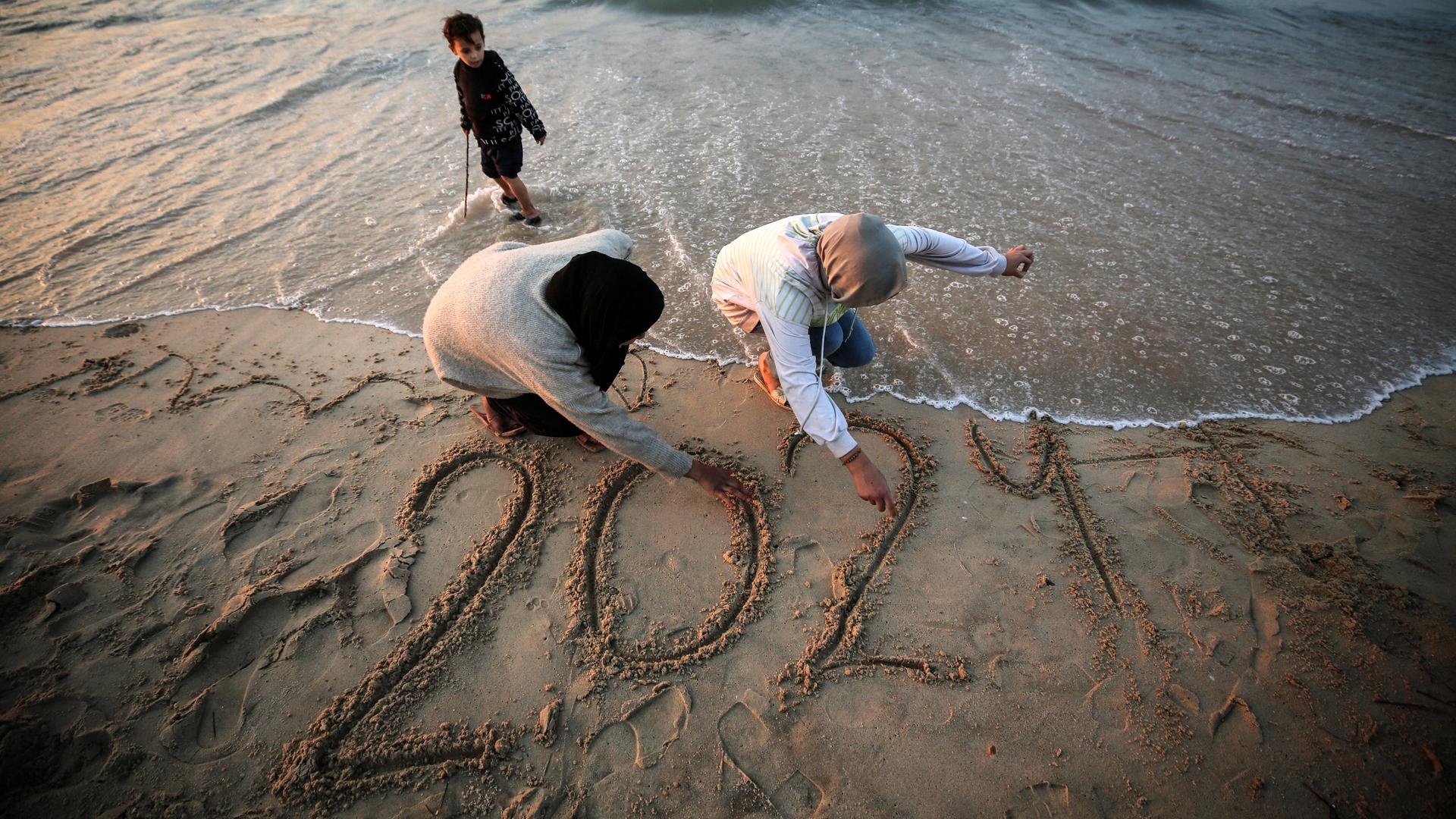 Am Strand von Gaza: Palästinensische Frauen schreiben 2024 als Zeichen der Hoffnung in den Sand