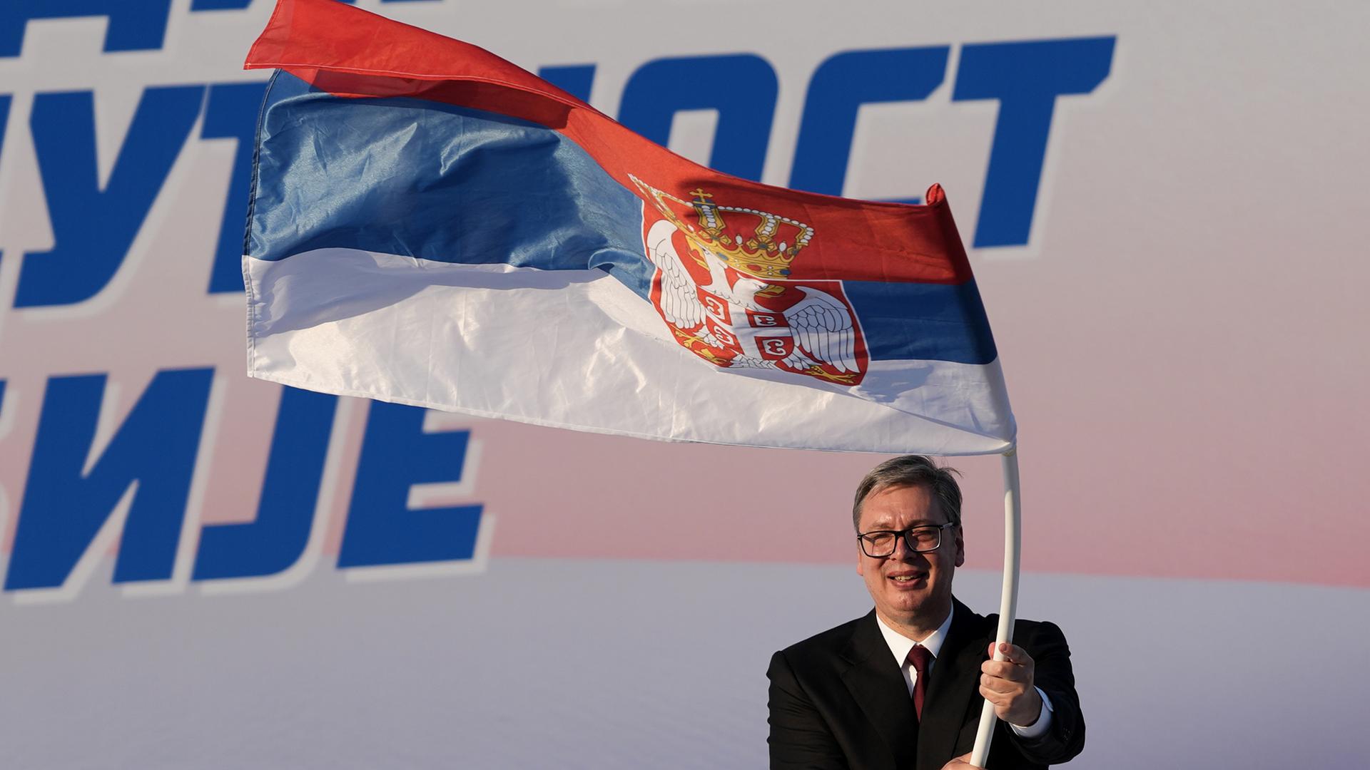 Der serbische Politiker Aleksandar Vucic schwingt eine Flagge seines Landes. Der serbische Politiker Aleksandar Vucic schwingt eine Flagge seines Landes.