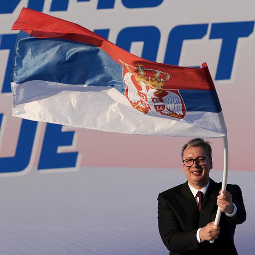 Der serbische Politiker Aleksandar Vucic schwingt eine Flagge seines Landes.