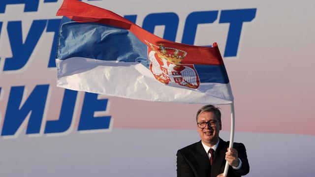Der serbische Politiker Aleksandar Vucic schwingt eine Flagge seines Landes.