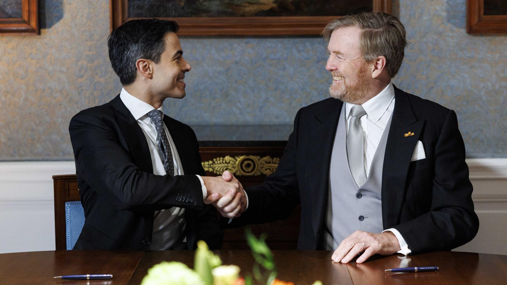 König Willem-Alexander und Premierminister Rob Jetten geben sich die Hand.