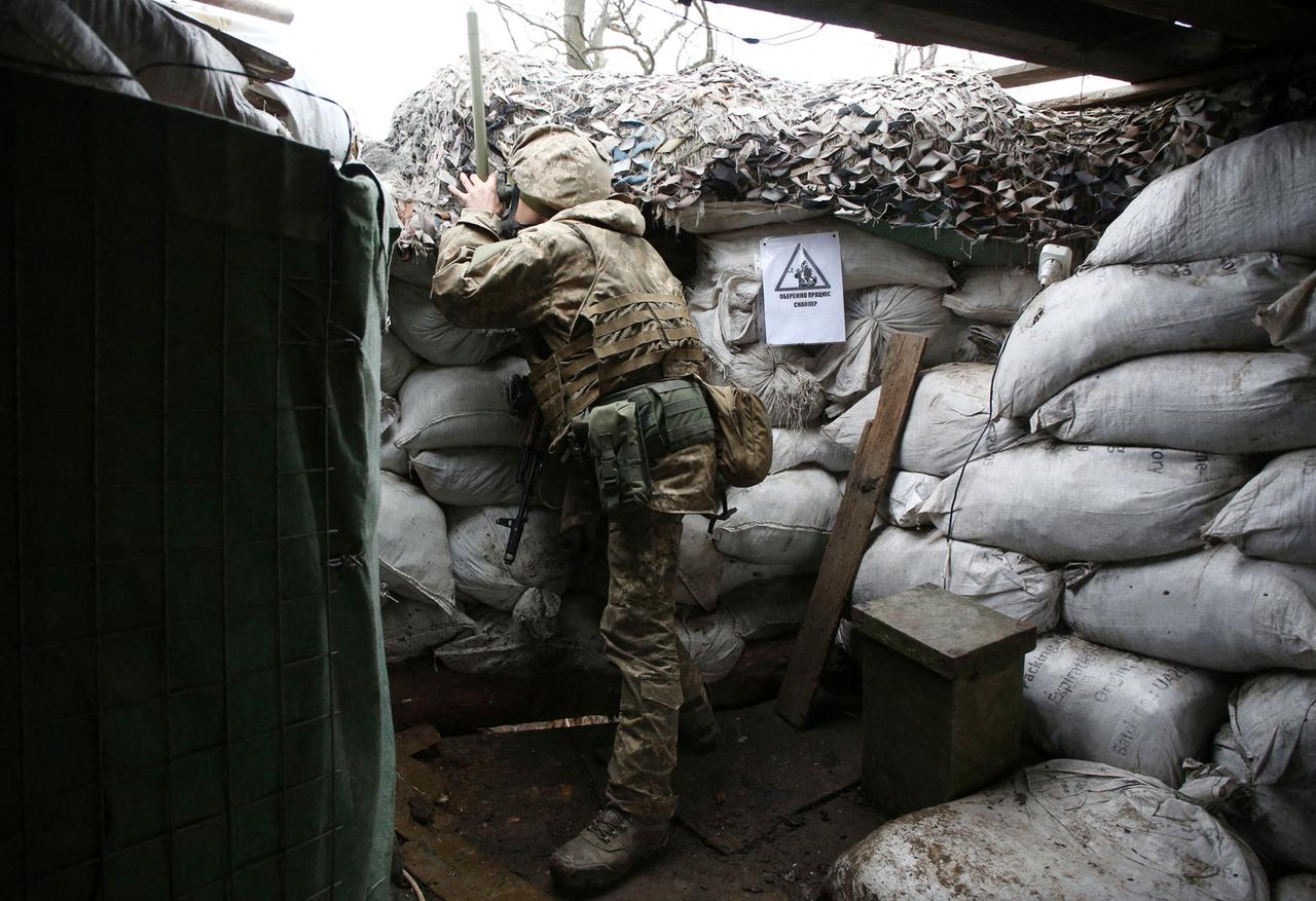 Ein Ukrainer beobachtet durch ein Fernrohr die Frontlinie zu Russland in der Nähe von Pesky, Donetsk am 14. Dezember 2021. 