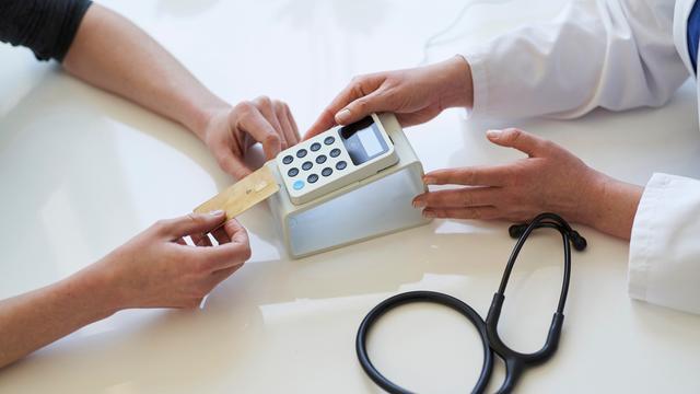 Doktor und Patient mit einer Krankenkassenkarte