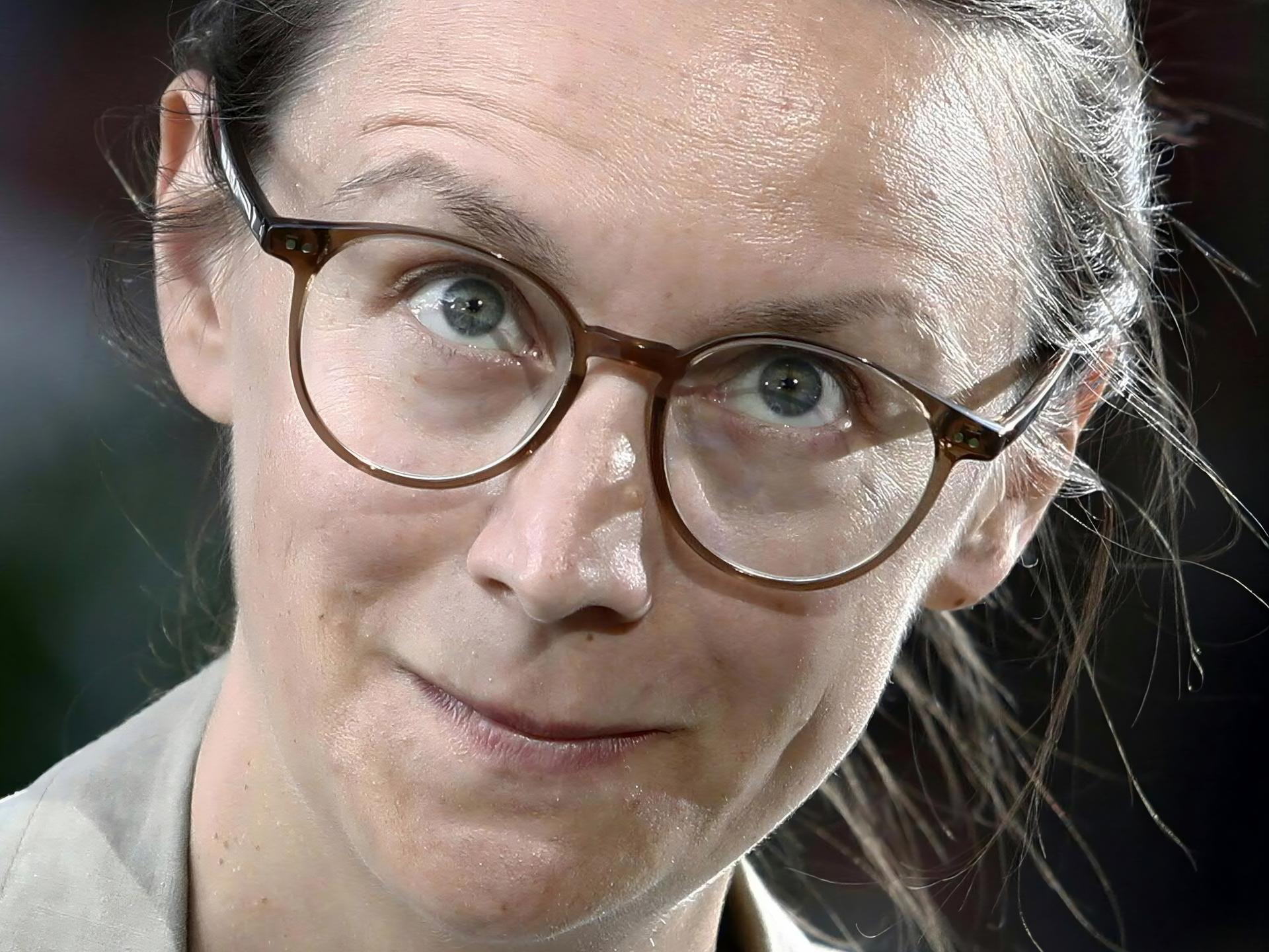 Nahaufnahme der Autorin Johanna Sebauer. Sie blickt durch ihre Brille direkt in die Kamera.