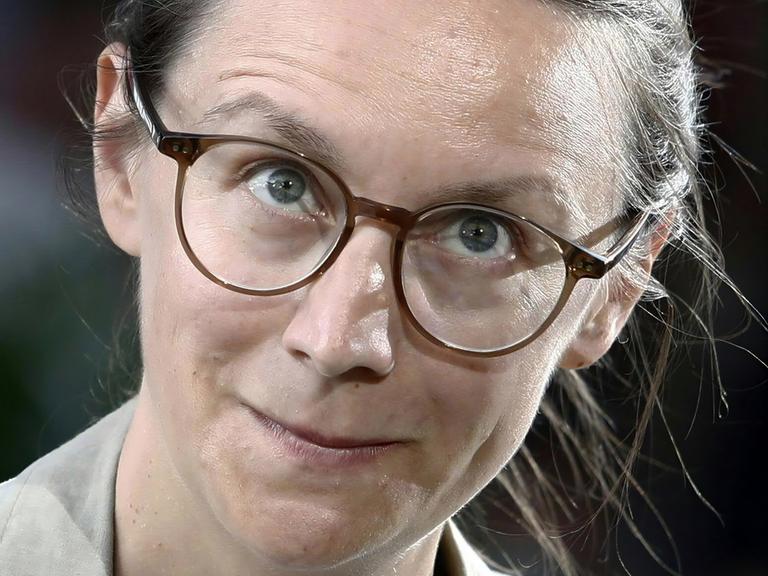 Nahaufnahme der Autorin Johanna Sebauer. Sie blickt durch ihre Brille direkt in die Kamera.