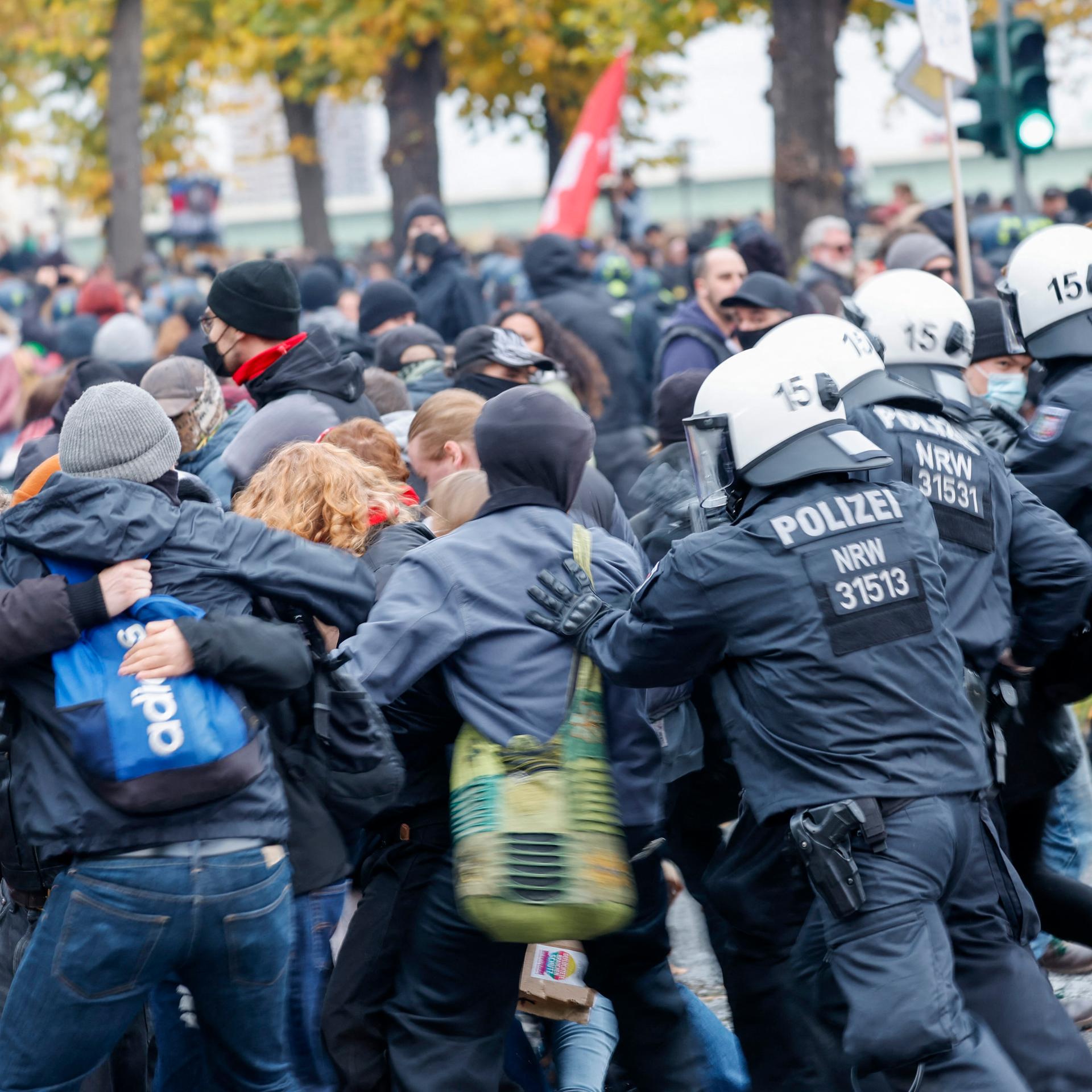 Mehrere Demonstranten werden von der Polizei in eine Richtung gedrängt.