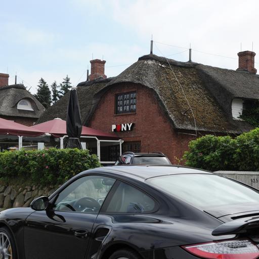 Der Club "Pony" in Kampen auf Sylt. Im Vordergrund steht ein schwarzer Porsche.
