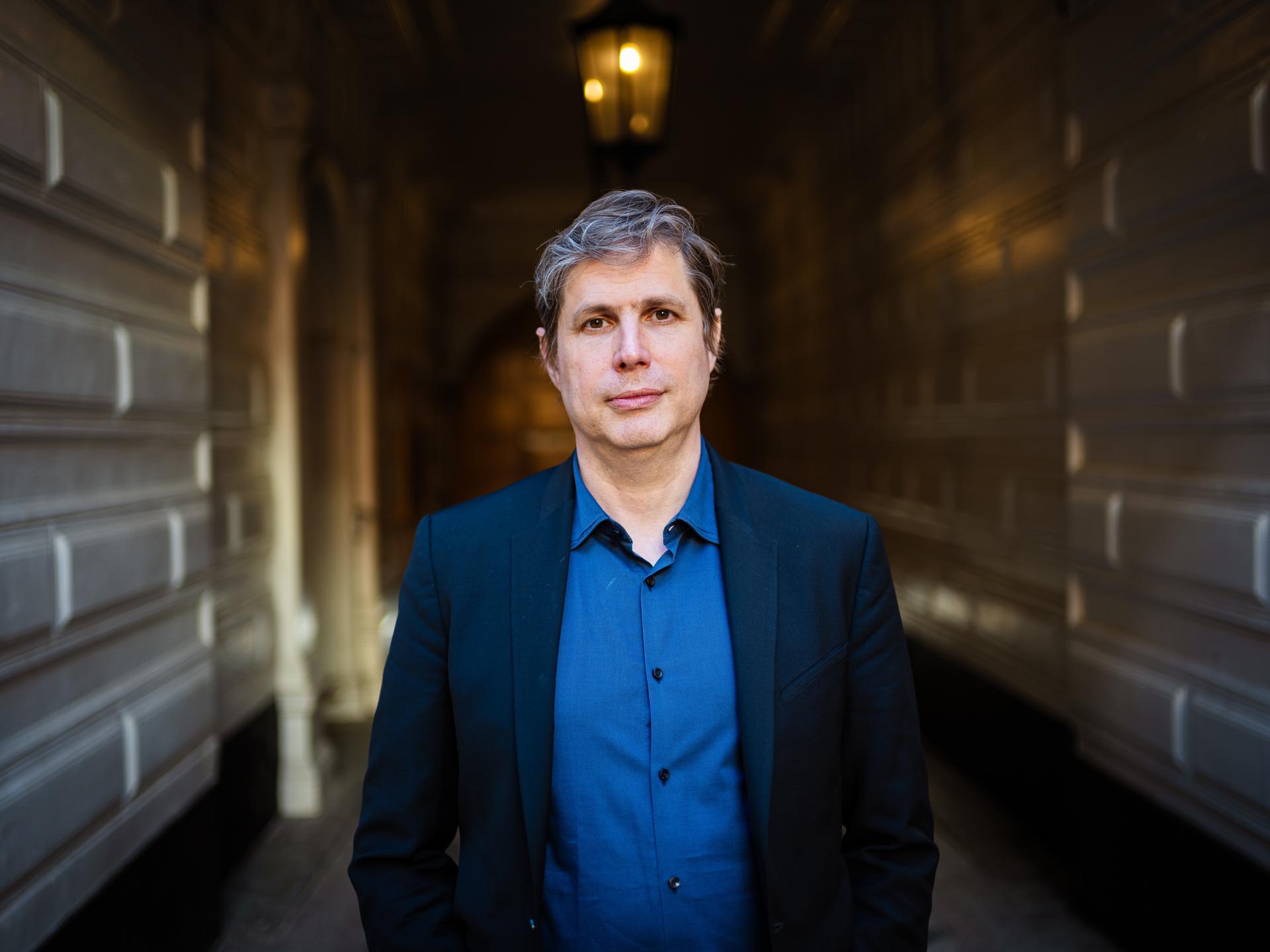 Der Schrifsteller Daniel Kehlmann steht in einem Hausflur