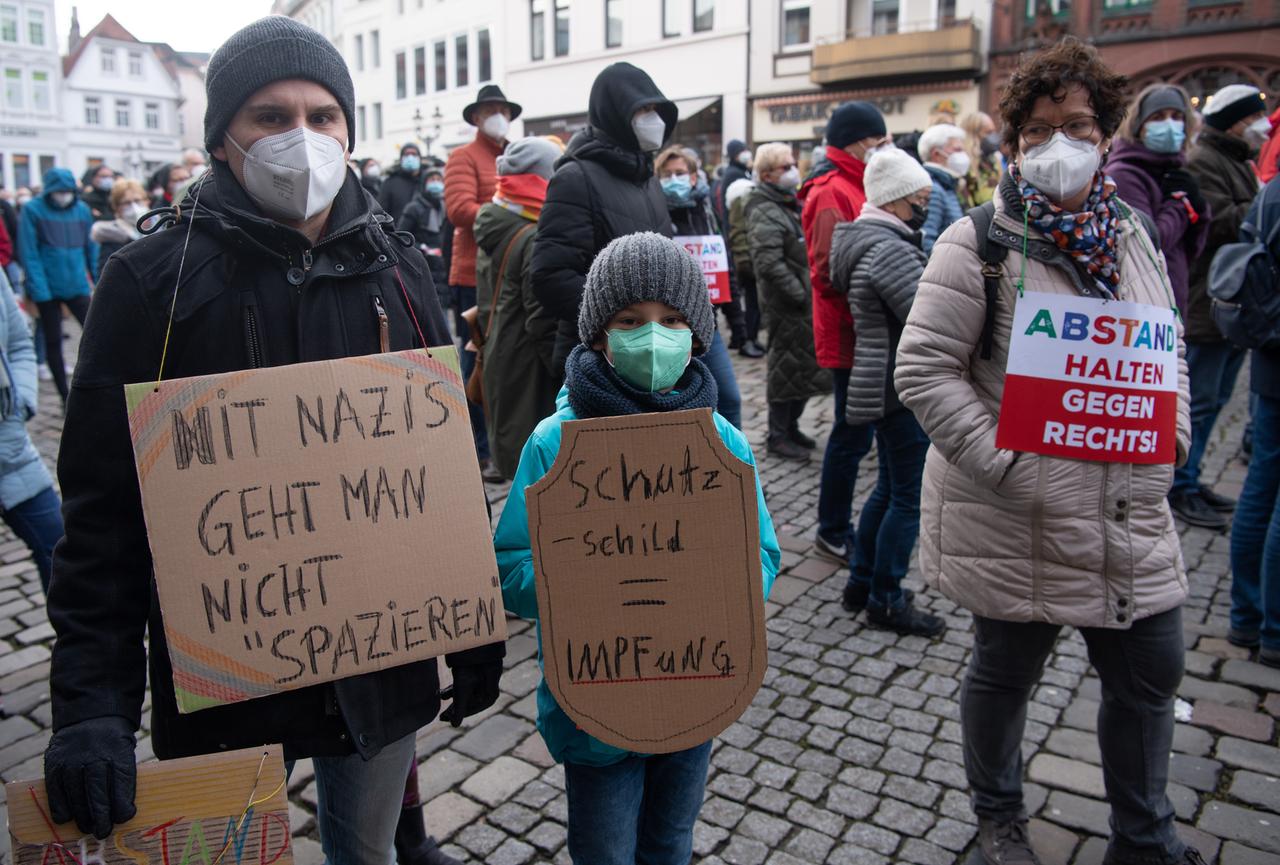 Das Bild zeigt zwei Demonstranten in der Stadt Minden , die gegen sogenannte Querdenker protestieren. 