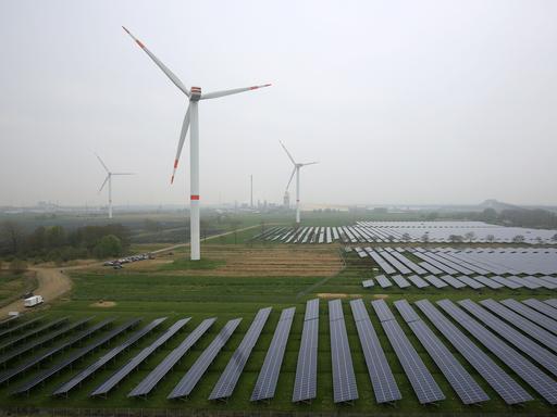 Auf einer früheren Ackerfläche stehen Windräder und diverse Solar-Paneele.