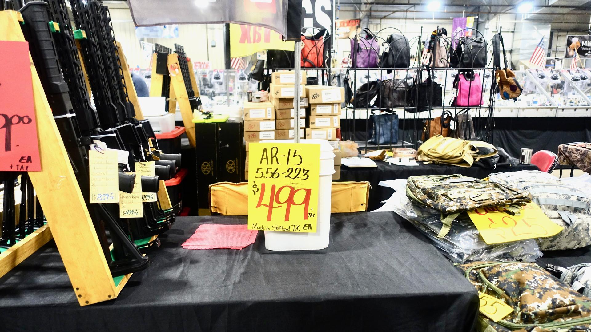 Waffen im Angebot für 499 Dollar liegen zwischen Stapeln von Kleidung und Handtaschen. Waffen im Angebot für 499 Dollar liegen zwischen Stapeln von Kleidung und Handtaschen.