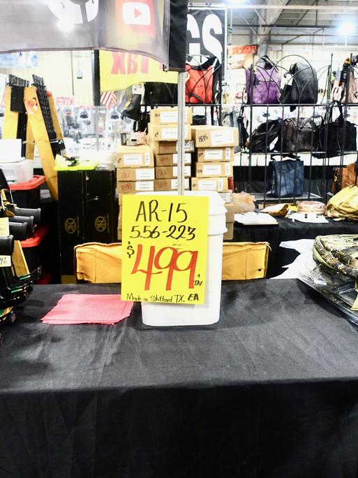 Waffen im Angebot für 499 Dollar liegen zwischen Stapeln von Kleidung und Handtaschen.
