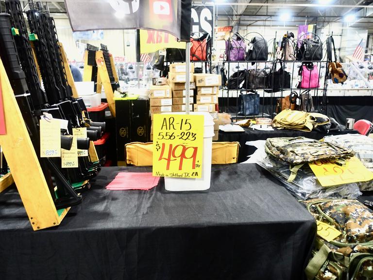 Waffen im Angebot für 499 Dollar liegen zwischen Stapeln von Kleidung und Handtaschen.