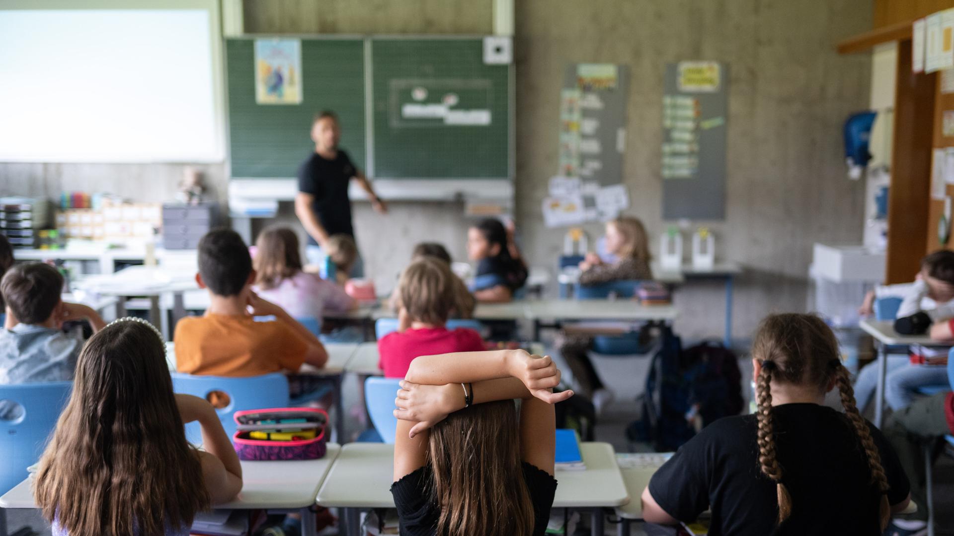 Schülerinnen und Schüler einer vierten Klasse einer Grundschule nehmen am Unterricht teil.