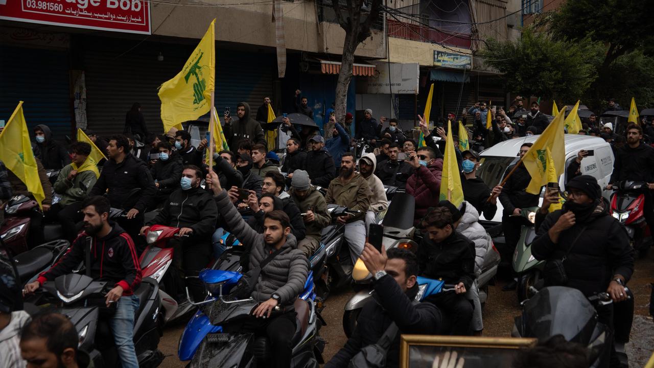 In einem Wohnviertel bei Beirut kehren geflüchtete Anwohner auf Mopeds zurück und halten teilweise die gelben Fahnen der schiitischen Hisbollah-Organisation hoch. 